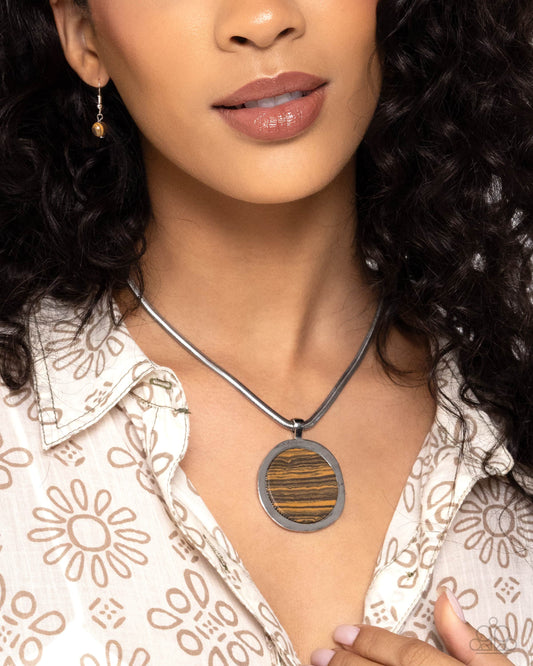 Pendant Puzzle Brown Necklace - Paparazzi Accessories  Strung along a flat, silver snake chain, a wood-like stone is pressed into a thick silver pendant for an elegantly earthy display. Features an adjustable clasp closure. As the stone elements in this piece are natural, some color variation is normal.  Sold as one individual necklace. Includes one pair of matching earrings.   Get The Complete Look! Earring: "Pendant Paradox - Brown" (Sold Separately)