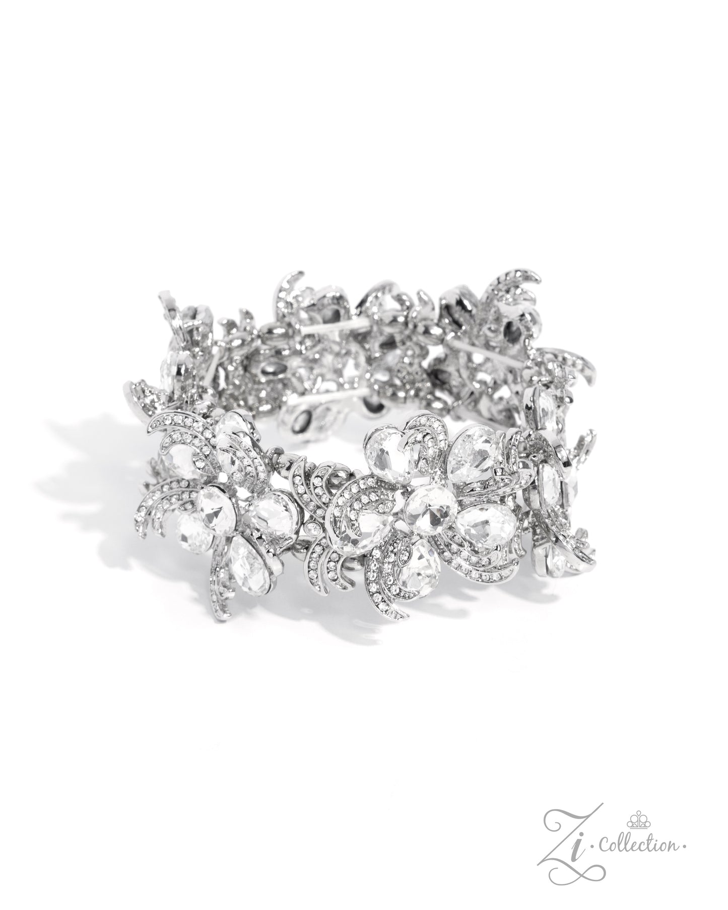 Indulgent Ideal White Rhinestone Stretch Zi Bracelet - Paparazzi Accessories Item #Z2425 Curls of white rhinestone-embellished silver frames in varying sizes and white teardrop gems bloom around shimmery luminescent round centerpieces into a collection of unique flowers adorned in dizzying, intricate detail. The flourish of florals is threaded whimsically around the wrist on elastic stretchy bands, resulting in an unforgettable statement piece that sparkles with sentiment. Sold as one individual bracelet