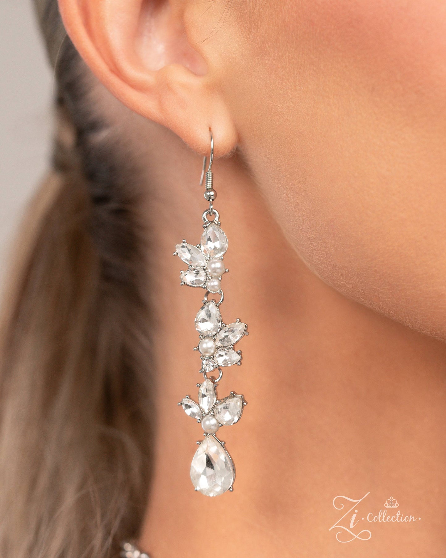 The Aleshia White Pearl 2024 Zi Necklace - Paparazzi Accessories Item #Z2410 Clusters of marquise-cut and teardrop gems, round white rhinestones, white pearls, and pieces of rhinestone-encrusted silver bars link together along the collar, creating an explosion of extravagant sparkle. The dramatic angles of the silver bars exaggerate the dramatic crystal-like radiance of each pronged gem, adding further dimension to the design. The size and intensity of the radically refined clusters slowly increase as th