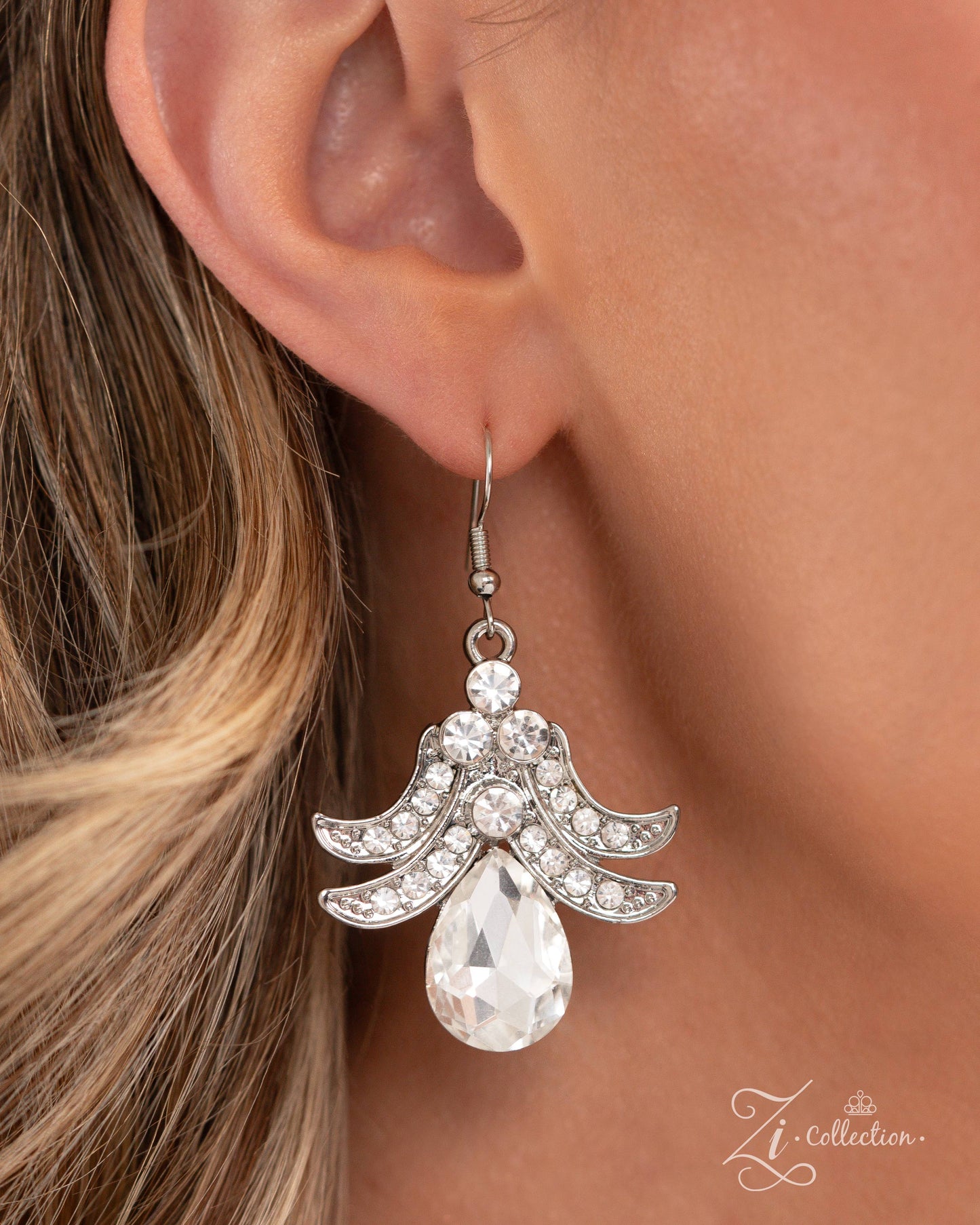 The Gesphania White Rhinestone 2024 Zi Necklace - Paparazzi Accessories Item #Z2403 Curls of white rhinestone-embellished silver frames in varying sizes, and white teardrop gems bloom along the neckline, leading the eye to a shimmery luminescent floral centerpiece adorned in dizzying, intricate detail. An additional flourish of shimmery silver curls and a white teardrop gem cascades below the floral centerpiece, resulting in an unforgettable statement piece that sparkles with sentiment. Features an adjust