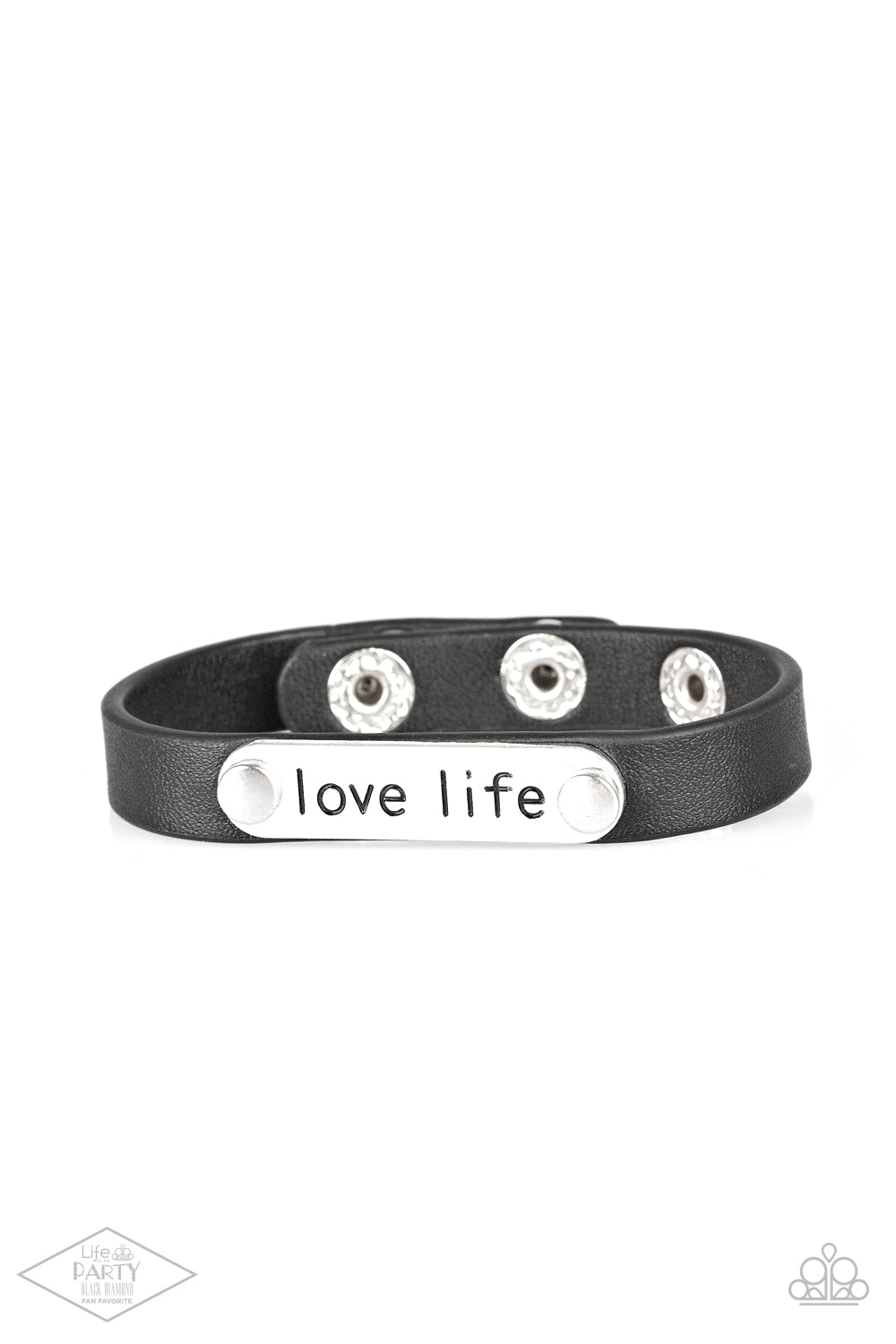 Love Life Black Wrap Bracelet - Paparazzi Accessories A silver plate engraved with the inspirational phrase “love life” is studded in place along a skinny strip of black leather. Brushed in a shiny finish, the dainty band wraps around the wrist for a simple seasonal style. Features an adjustable snap closure. Sold as one individual bracelet. This Fan Favorite is back in the spotlight at the request of our 2021 Life of the Party member with Black Diamond Access, Robert F.