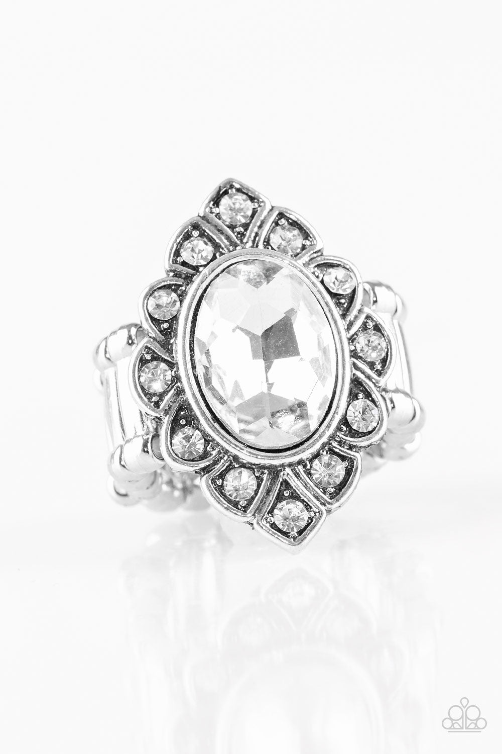 Power Behind The Throne White Ring - Paparazzi Accessories A faceted white gem is pressed into a marquise-shaped silver frame radiating with glittery white rhinestones for a regal look. Features a stretchy band for a flexible fit. Sold as one individual ring.