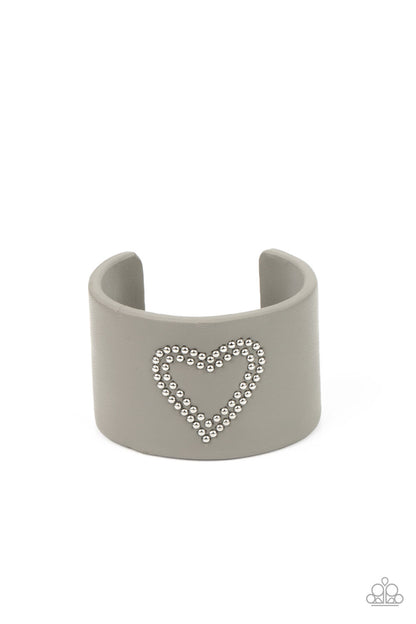 Rodeo Romance Silver Cuff Bracelet - Paparazzi Accessories  The center of an Ultimate Gray leather cuff is studded in a charming heart pattern, creating a rustically romantic look around the wrist.  Sold as one individual bracelet.