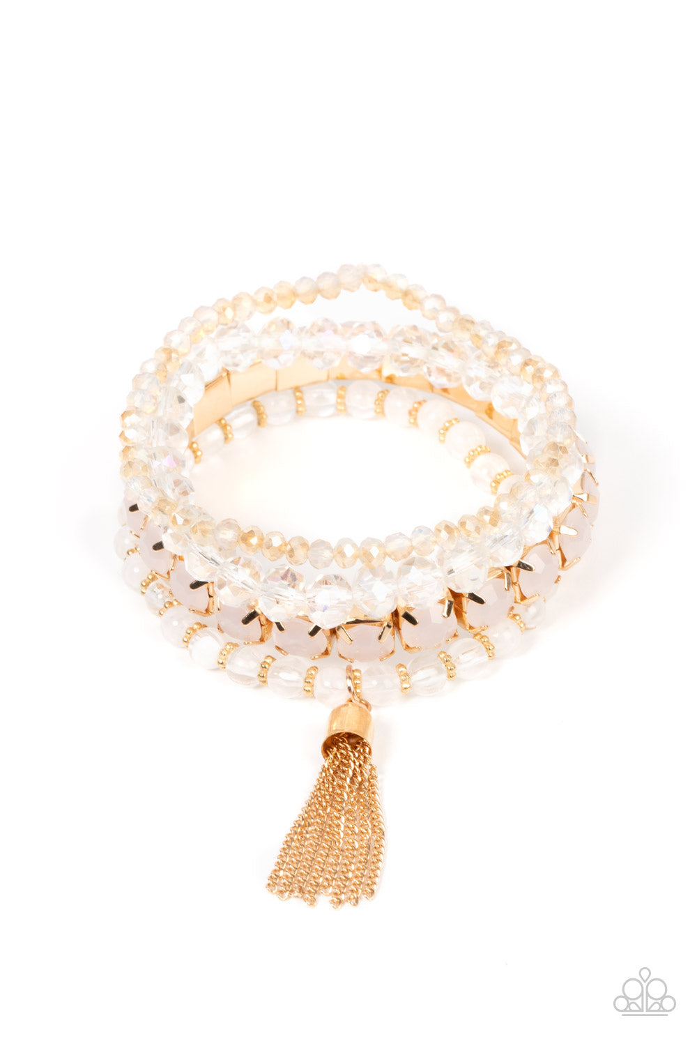 Day Trip Trinket Gold Bracelet - Paparazzi Accessories Pinched in gold fittings, a stretchy band of dewy rhinestones joins mismatched strands of golden, glassy, and iridescent crystal-like and stretchy bracelets around the wrist. A single gold chain tassel dances from the crystalline compilation for a final flirty finesse. Sold as one set of four bracelets.