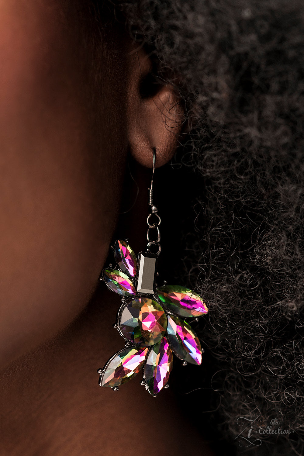 Clusters of hematite and oil spill rhinestones link together along the collar, creating an explosion of futuristic sparkle. The faceted edges of each emerald-, round-, or marquise-cut gem exaggerate their dramatic angles and kaleidoscopic radiance, as the pronged settings add dimension to the design. The size and intensity of the cosmic clusters slowly increases as they lead to the center, where the eye rests at the fiercest focal point.