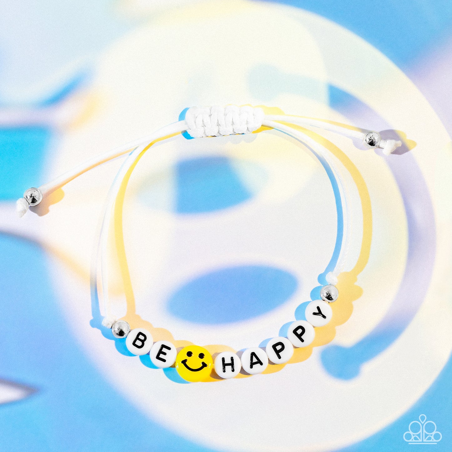 I Love Your Smile White Bracelet - Paparazzi Accessories Strung along a white string, white beads are stamped with black letters that make out the phrase "Be Happy." A yellow bead with a smiley face separates the words "be" and "happy" for a cheery pop of color. Silver beads border the cheery beads, grounding the design to the beads hanging at the end of the adjustable sliding closure that wraps around the wrist. Features an adjustable sliding knot closure. Sold as one individual bracelet.