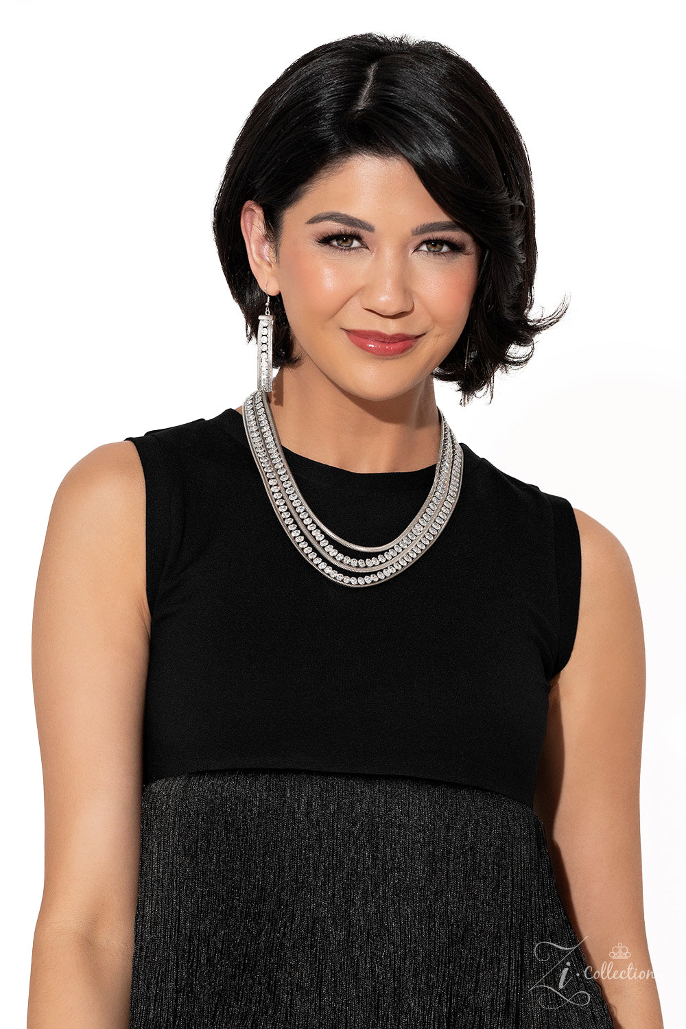Tenacious White 2023 Zi Collection Necklace - Paparazzi Accessories Flat, silver snake chains alternate with rows of explosive sparkle, layering into a dynamic lineup of grit and glitz. The meticulous placement and uniform sizing of the glittery, white rhinestones are contrasted by the slithering movement of the snake chains, as the strands drape into a dramatic finish. Features an adjustable clasp closure.