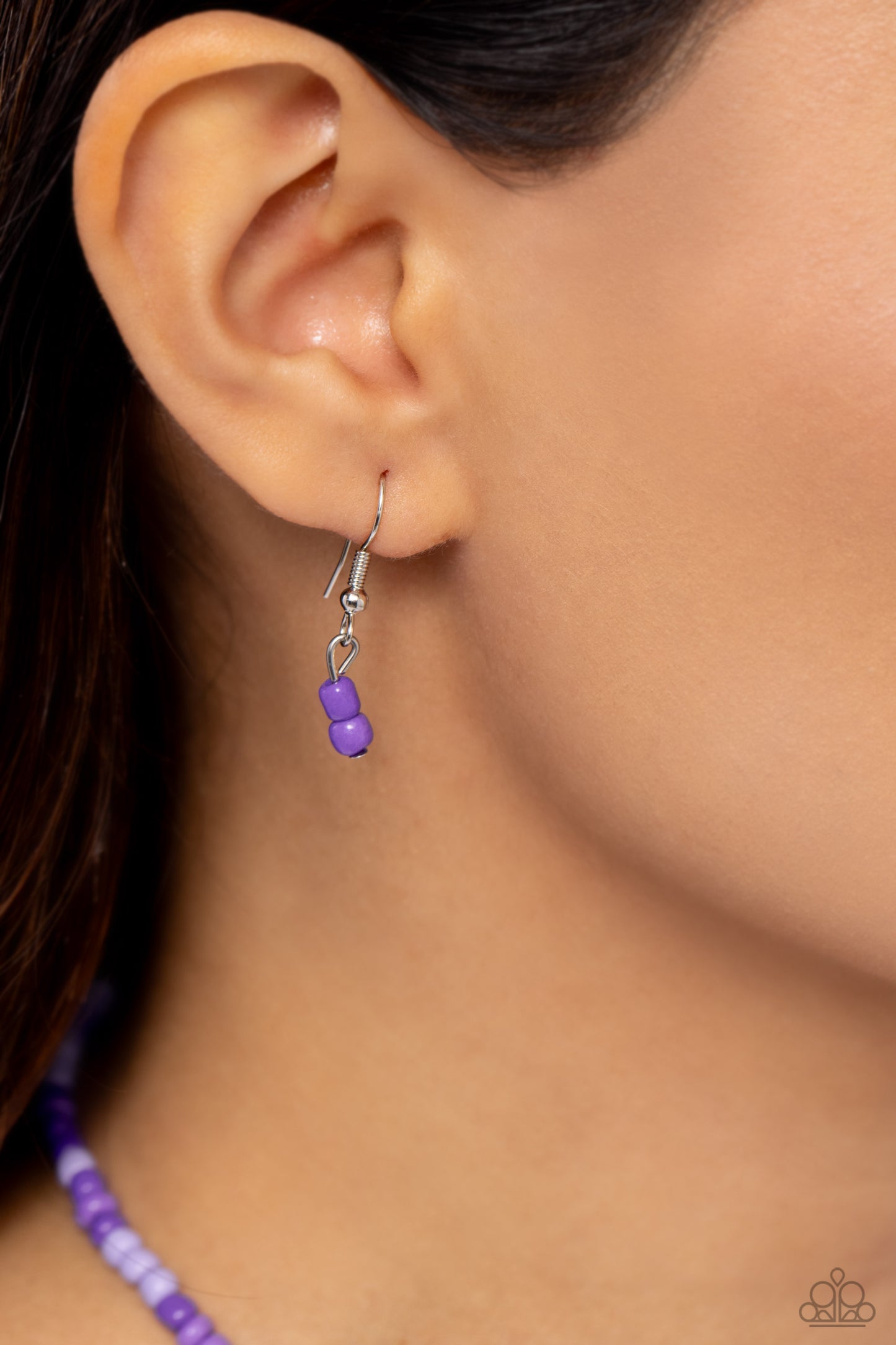 Pearly Possession Purple Necklace - Paparazzi Accessories Infused along an invisible string, lavender, plum, and purple seed beads combine with sporadically placed purple discs, and glossy white and heart-shaped pearls for a vibrant pop of color along the neckline. A silver peace sign featuring blue and purple paint dangles from the colorful strand for a groovy finish. Features an adjustable clasp closure. Sold as one individual necklace. Includes one pair of matching earrings. P2DA-PRXX-141XX