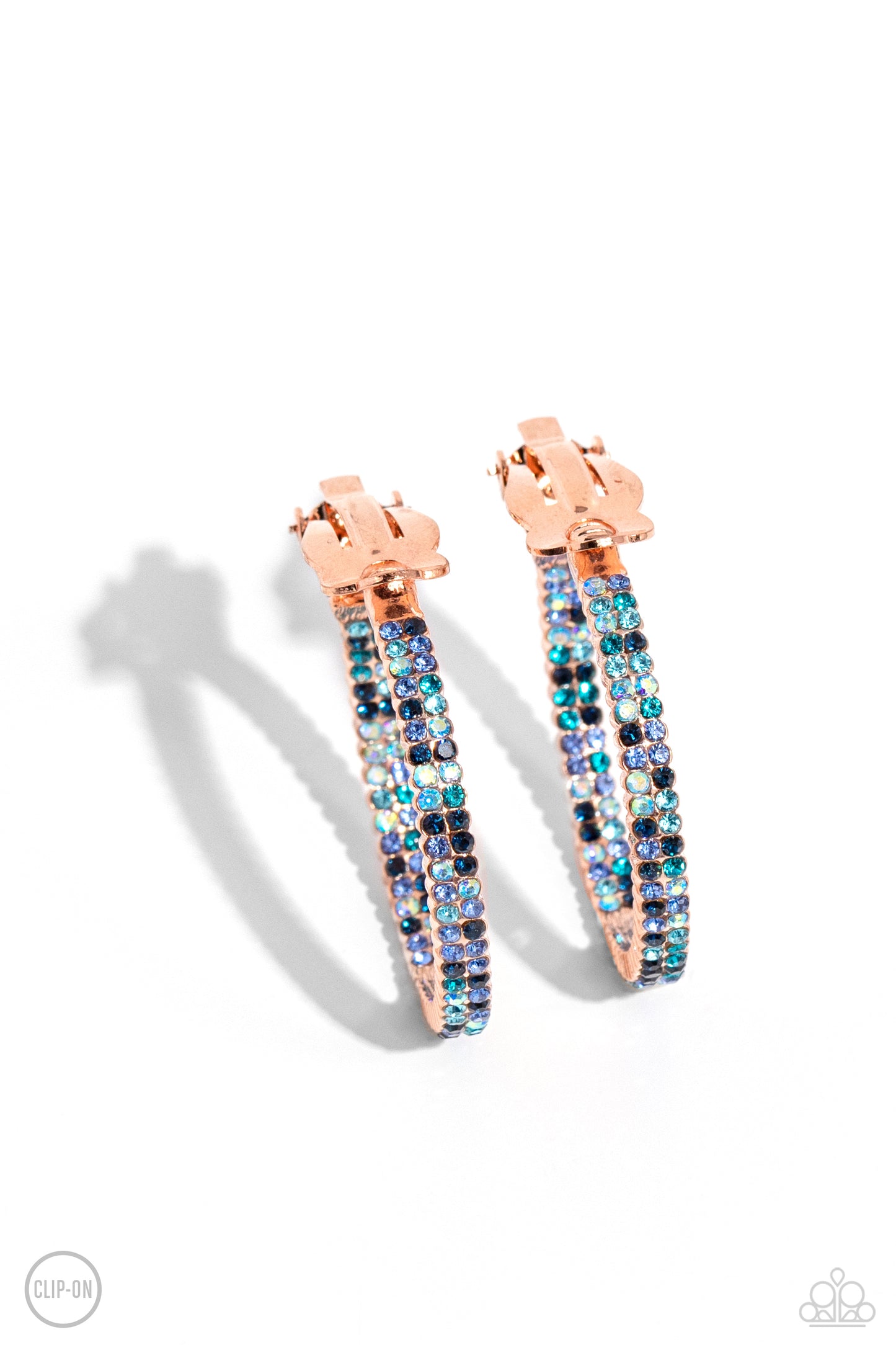 Outstanding Ombre Copper Clip-On Earring - Paparazzi Accessories The front half and lower inner curve of a textured shiny copper hoop are encrusted in dazzling ombré shades of blue for a flawless look. Earring attaches to a standard clip-on fitting. Hoop measures approximately 1" in diameter. Due to its prismatic palette, color may vary. Featured inside The Preview at Made for More! Sold as one pair of clip-on earrings. P5CO-CPSH-032XX