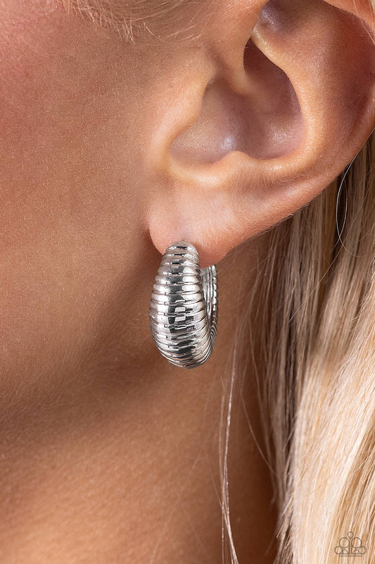 Textured Tenure Silver Hoop Earring - Paparazzi Accessories  Featuring a beveled surface, a thick textured silver frame curves into a single hoop, creating an attention-grabbing shimmer. Earring attaches to a standard post fitting. Hoop measures approximately 3/4" in diameter.  Sold as one pair of hoop earrings.  P5HO-SVXX-375XX