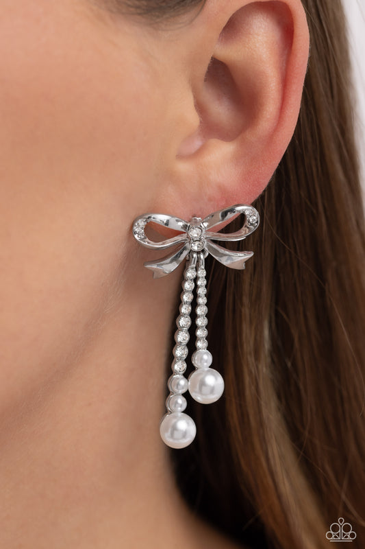 Bodacious Bow White Post Earring - Paparazzi Accessories  Adorned in sparkling white rhinestones, high-sheen bands of silver curl and loop into a stunning bow charm, creating a classy statement at the ear. White rhinestones encased in scalloped silver fittings, featuring white pearls that slowly increase in size dangle from the bow charm adding a refined tassel to the stunning display. Earring attaches to a standard post fitting.  Sold as one pair of post earrings.  P5PO-WTXX-383XX