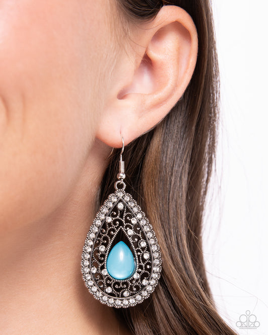 Cloud Nine Couture Blue Earring - Paparazzi Accessories A glimmering Harbor Blue acrylic teardrop seemingly floats inside a border of studded silver filigree, resulting in an enchanting scalloped frame. A smattering of glassy white rhinestones are sprinkled along the vine-like backdrop, matching the outer rim of white rhinestones for a tasteful finish. Earring attaches to a standard fishhook fitting. Sold as one pair of earrings. SKU: P5WH-BLXX-261XX
