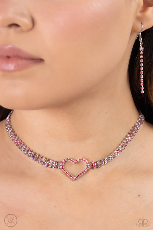 Rows of Romance Pink Heart Choker Necklace - Paparazzi Accessories  Featuring sleek square fittings, a dramatic rose rhinestone heart-shaped frame glitters at the center of blinding rows of glassy rose, fuchsia, violet, and light pink rhinestones also set in silver square fittings, resulting in a flirtatious sparkle around the neck. Features an adjustable clasp closure.  Sold as one individual choker necklace. Includes one pair of matching earrings.  SKU: P2CH-PKXX-032XX