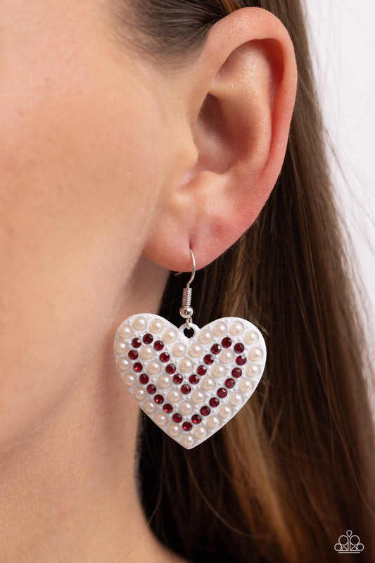 Romantic Reunion White Heart Earring - Paparazzi Accessories A white-painted heart is covered in rows of tiny red rhinestones and white pearls, emitting radiant shimmer as it swings from the ear. Earring attaches to a standard fishhook fitting. Sold as one pair of earrings. SKU: P5RE-WTXX-611XX