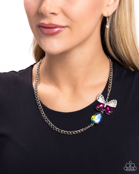 Fluttering Finesse Multi Butterfly Necklace - Paparazzi Accessories  Infused along a silver chain, an oversized butterfly flutters above a UV shimmery teardrop. The upper wings of the butterfly feature white rhinestones, while the bottom wings are formed from faceted magenta teardrops for a whimsical finish. Features an adjustable clasp closure. Due to its prismatic palette, color may vary.  Sold as one individual necklace. Includes one pair of matching earrings.  SKU: P2ST-MTXX-136XX