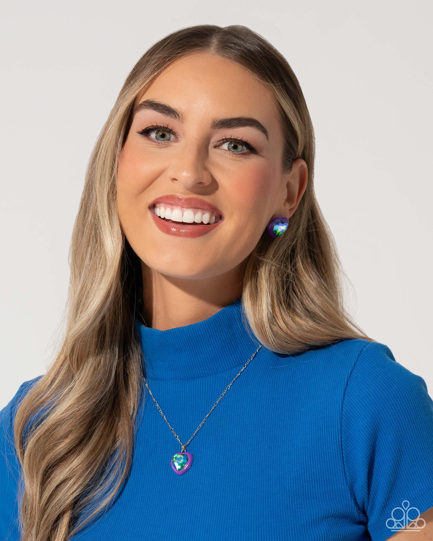 Heartfelt Haute Purple Post Earring - Paparazzi Accessories Pressed in a border of purple paint, an oversized UV shimmery heart gem glimmers from the ear, resulting in a romantic-inspired display. Earring attaches to a standard post fitting. Sold as one pair of post earrings. SKU: P5PO-PRXX-025UM Get The Complete Look! Necklace: "Heartfelt Hope - Purple" (Sold Separately)