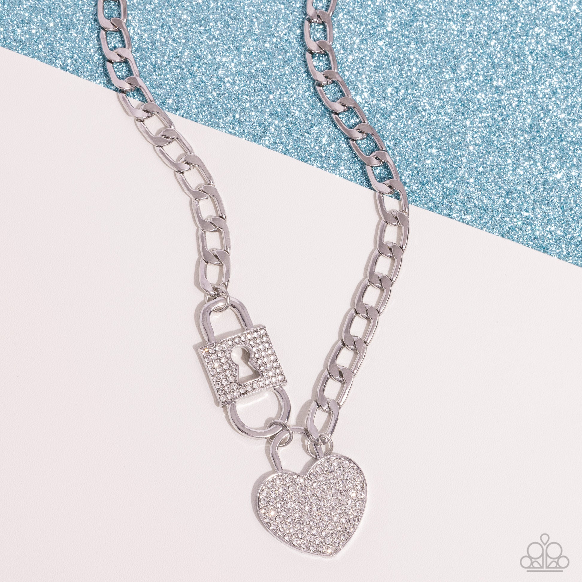 Lock Up Your Love White Necklace - Paparazzi Accessories (June 2024 LOP)    Embellished with glistening white rhinestones, a silver lock pendant and heart padlock interconnect from a silver curb chain for a romantic-inspired display of shimmer. Features an adjustable clasp closure.  Sold as one individual necklace. Includes one pair of matching earrings.  Item #P2ST-WTXX-144XX