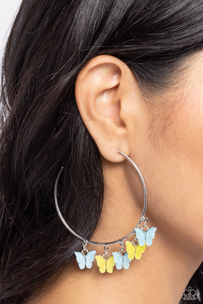 Bemusing Butterflies Blue Hoop Earring - Paparazzi Accessories  Attached along an oversized silver hoop, various blue and yellow butterflies flutter and fly along the ear for a whimsical finish. Earring attaches to a standard post fitting. Hoop measures approximately 2 1/4" in diameter.  Sold as one pair of hoop earrings.  P5HO-BLXX-065XX
