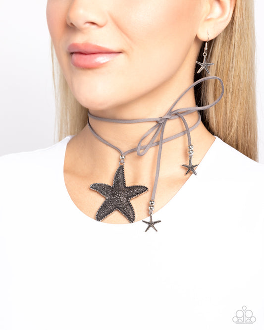 Starfish Sentiment Silver Choker Necklace - Paparazzi Accessories Infused with silver beaded and studded oversized starfish accents, a lengthened strip of gray suede double wraps around the neck, creating a layered choker necklace. Two whimsical silver starfish charms swing from the ends as a silver bead slides up and down the suede strands, adjusting the length of the coastal piece. Sold as one individual necklace. Includes one pair of matching earrings. SKU: P2SE-SVXX-174XX