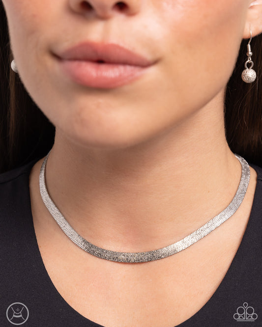 Simply Scintillating Silver Choker Necklace - Paparazzi Accessories  Dusted with dainty shimmer, a curved collection of high-sheen silver flat chain connects around the collar for a simply shimmery statement. Features an adjustable clasp closure.  Sold as one individual choker necklace. Includes one pair of matching earrings.  SKU: P2CH-SVXX-109XX