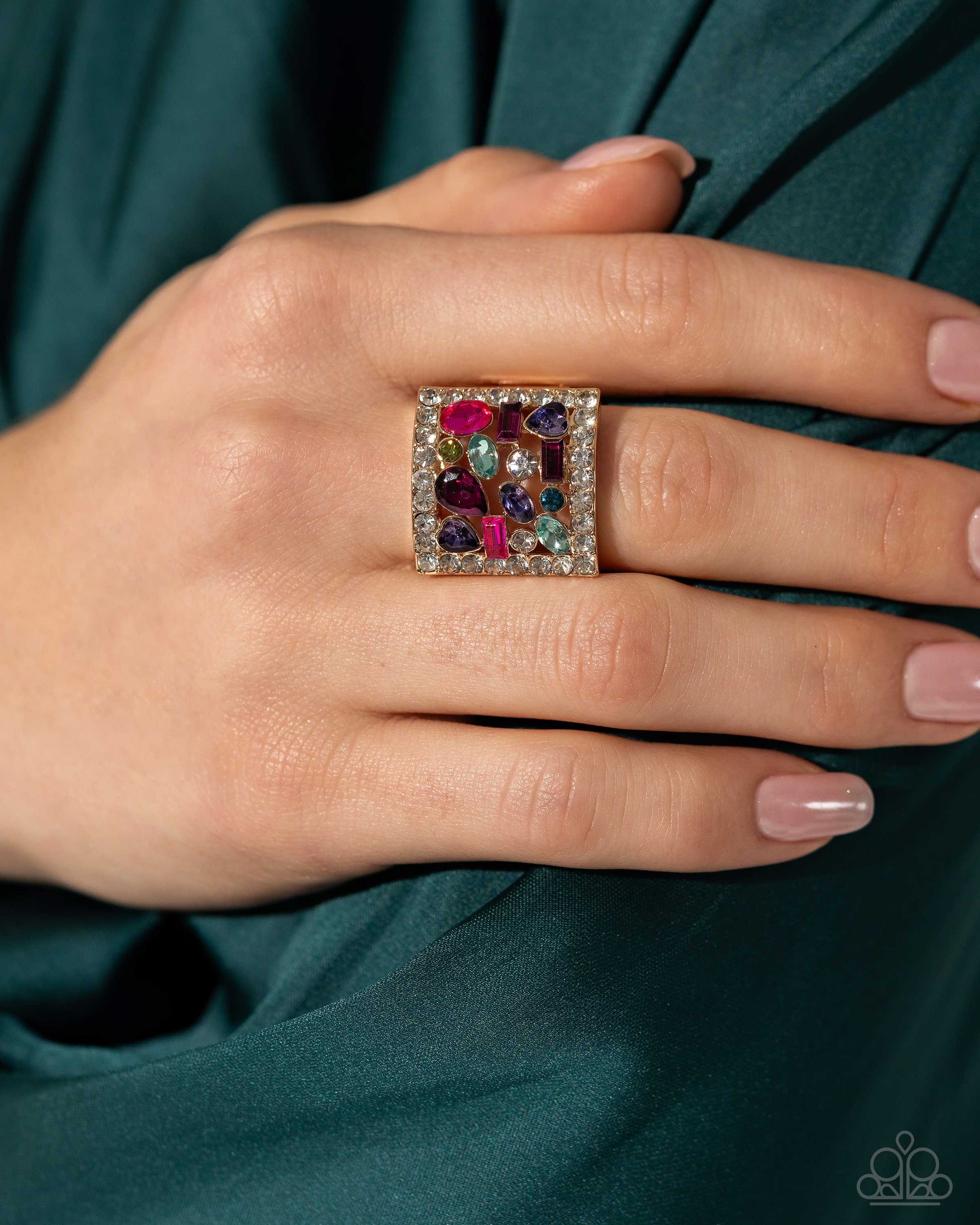 Framed Finesse Multi Ring - Paparazzi Accessories (June 2024 LOP)  Bordered in dainty white rhinestones, an exaggerated, airy gold square frame glistens atop the finger. Scattered through its airy middle, a collection of multicolored gems and rhinestones in various cuts completes the look with a dramatic flair. Features a stretchy band for a flexible fit.  Sold as one individual ring.  Item #P4RE-MTXX-059XX