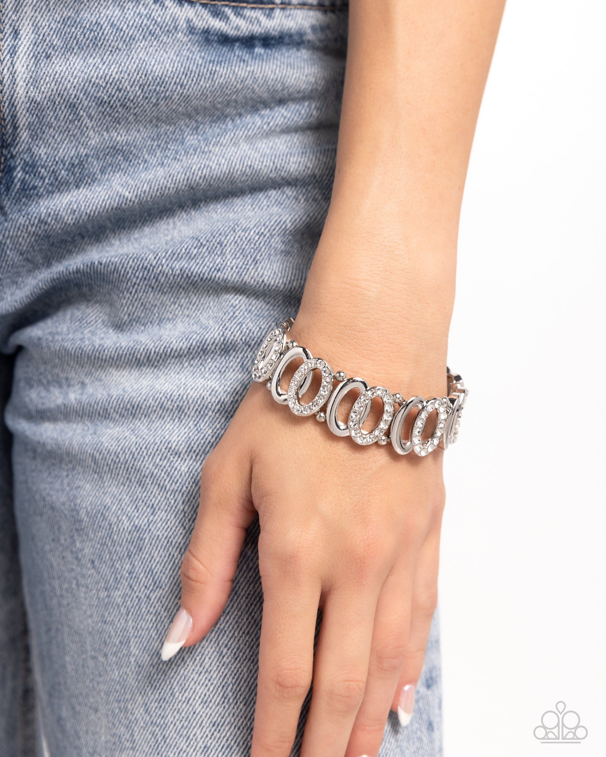 Refined Rarity White Rhinestone Stretch Bracelet - Paparazzi Accessories  A collection of two interlocking silver ovals, one encrusted in white rhinestones, separated by a duo of silver beads wraps along the wrist on elastic stretchy bands for a timeless, twisted look.  Sold as one individual bracelet.  P9RE-WTXX-596XX