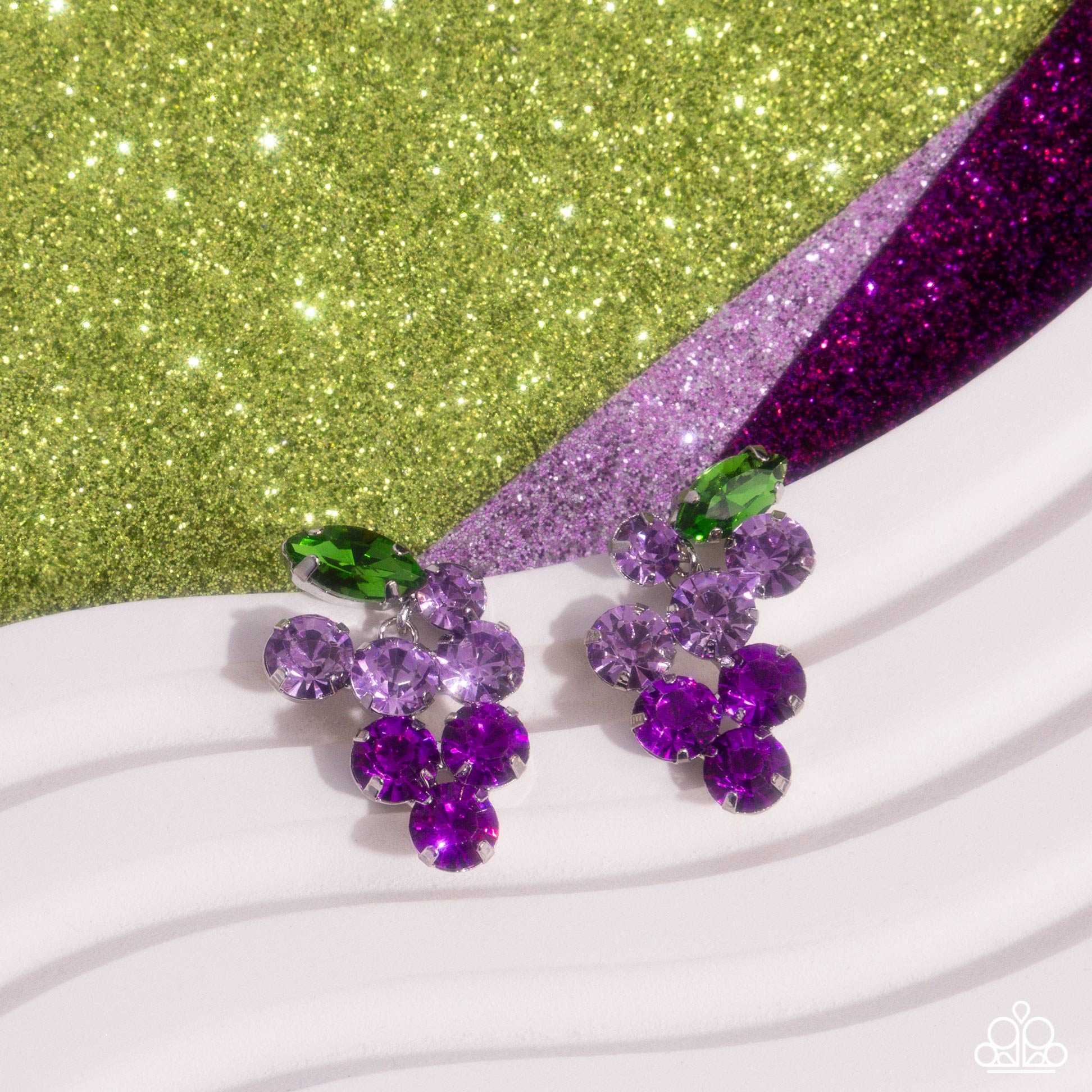 Grapevine Grace Purple Post Earring - Paparazzi Accessories  Pronged in silver fittings, a collection of round light purple rhinestones fade to darker purple rhinestones with a solitaire green marquise-cut leaf for an ombré, glittery grape-inspired display. Earring attaches to a standard post fitting.  Sold as one pair of post earrings.  P5PO-PRXX-034XX