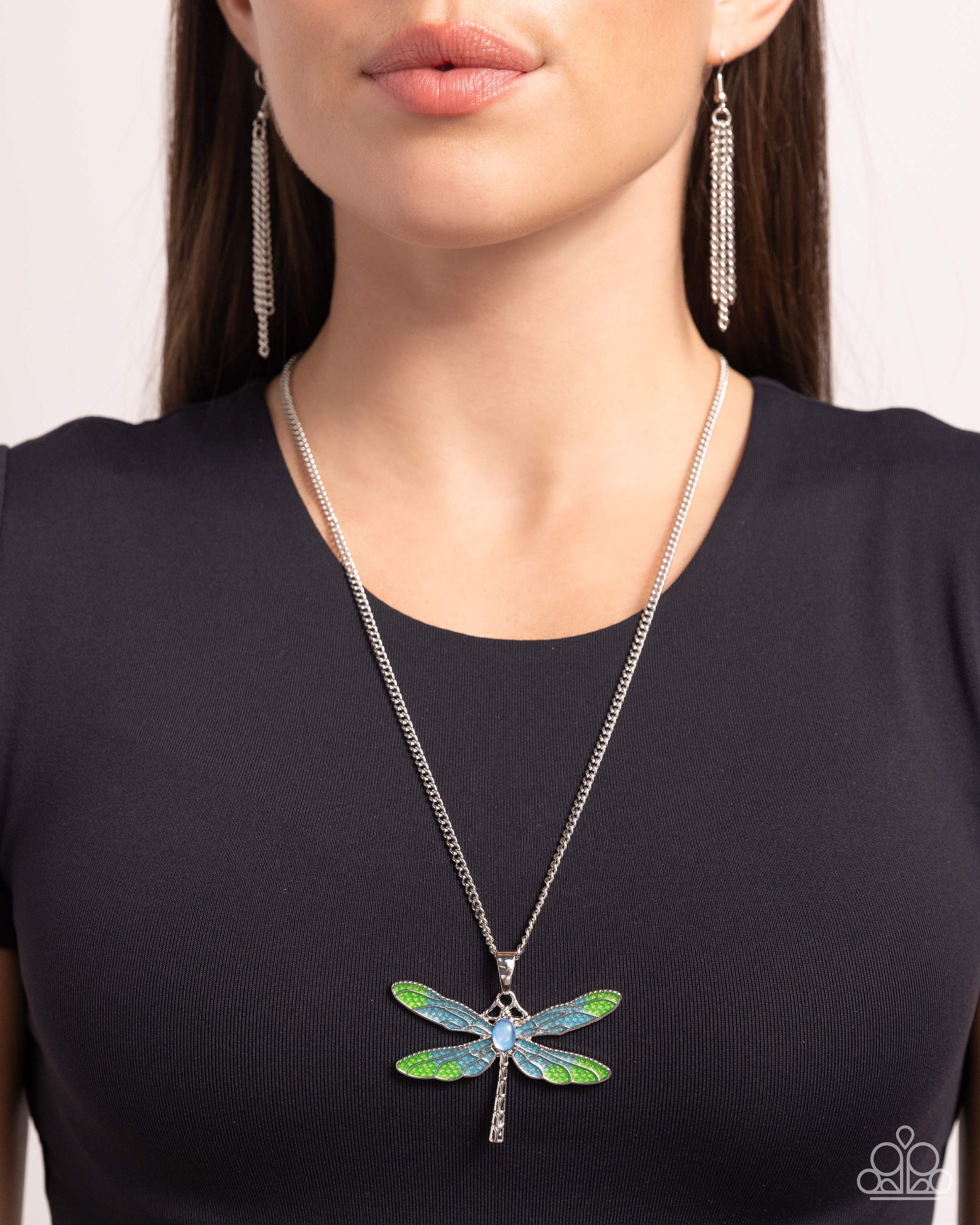 DRAGONFLY to the Sky Blue Necklace - Paparazzi Accessories Featuring a classic silver chain, a Capri Blue and light green painted silver dragonfly pendant glides along the neckline for a colorfully rustic centerpiece. An opalescent blue oval bead is pressed in the center of the display while textured silver connects and creates the rest of the dragonfly's body for additional eye-catching color and character. Features an adjustable clasp closure. Includes one pair of matching earrings. P2RE-BLXX-439XX