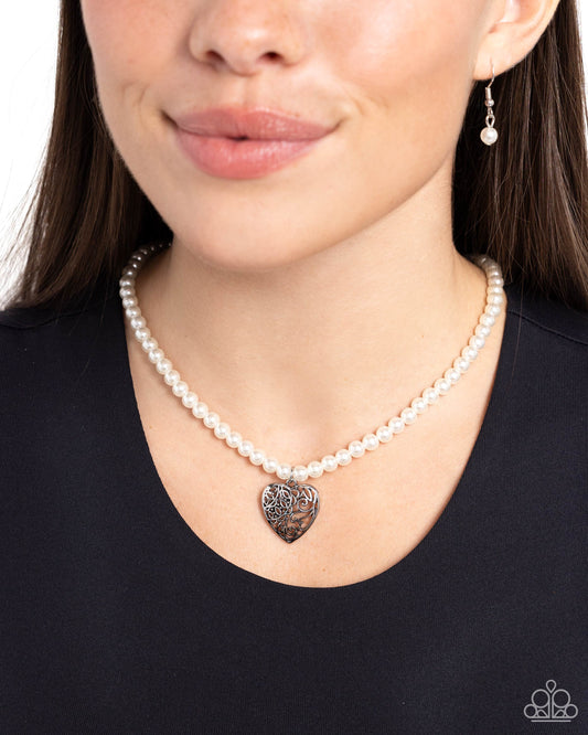 Filigree Infatuation White Pearl Heart Necklace - Paparazzi Accessories  A dainty collection of glossy white pearls gives way to an oversized filigree-filled silver heart frame, creating an antiqued locket-inspired look. Features an adjustable clasp closure.  Sold as one individual necklace. Includes one pair of matching earrings.  SKU: P2RE-WTXX-691XX