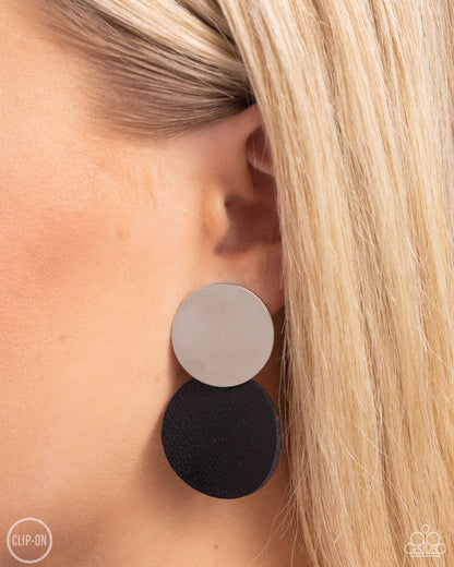 Leather Leader Black Clip-On Earring - Paparazzi Accessories  An oversized silver disc gives way to an even larger disc of black leather for a badlands basic. Earring attaches to a standard clip-on fitting.  Sold as one pair of clip-on earrings.  SKU: P5CO-BKXX-095XX