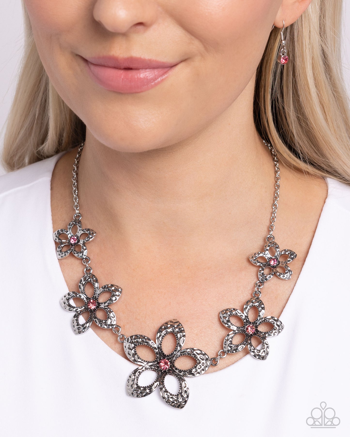 Faithful Florals Pink Necklace - Paparazzi Accessories  Delicately hammered in antiqued detail, airy silver flowers with silver studded detail and rose rhinestone centers gradually increase in size as they cascade around the neckline, creating a whimsically bold look. Features an adjustable clasp closure.  Sold as one individual necklace. Includes one pair of matching earrings.  P2ST-PKXX-178XX