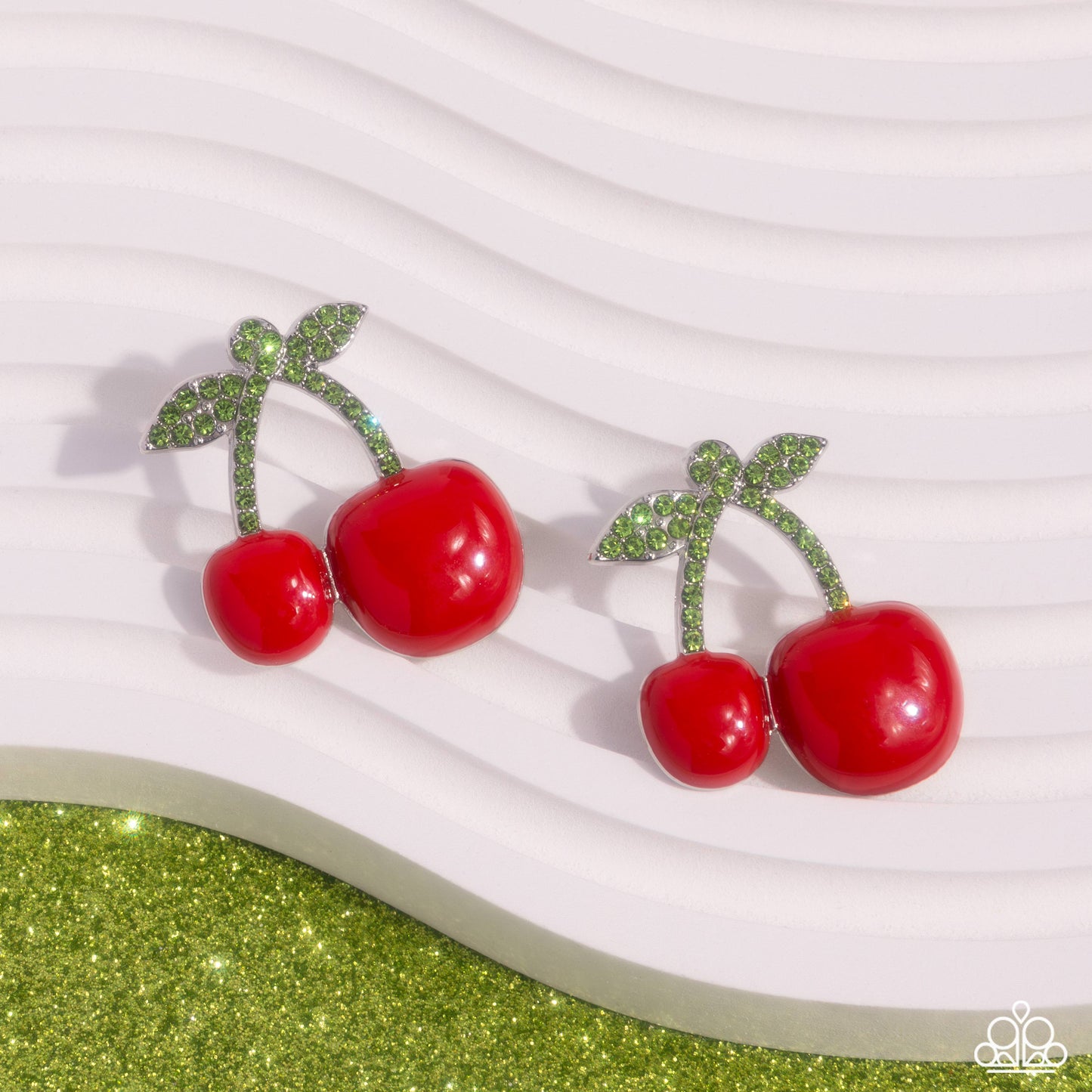Charming Cherries Red Post Earring - Paparazzi Accessories  Embellished in light green rhinestones, silver stems featuring a vibrant duo of red cherries in varying sizes hang below the ear for a fantastic fruity display. Earring attaches to a standard post fitting.  Sold as one pair of post earrings.  SKU: P5PO-RDXX-064XX