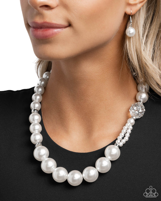 Crystal Class White Pearl Necklace - Paparazzi Accessories Infused along an invisible string, a collection of oversized glossy white pearls and silver rings that are interspersed throughout the design loop around the neckline. A crystal-like, multi-faceted bead and dainty double-stranded pearls attach to one side of the design for additional interest and appeal. Features an adjustable clasp closure. Sold as one individual necklace. Includes one pair of matching earrings. P2ST-WTXX-157XX