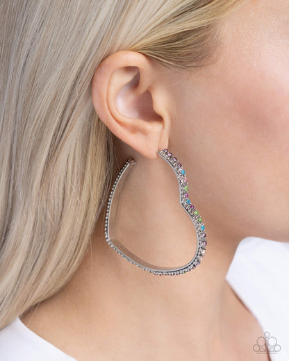 Halftime Hearts Multi Hoop Earring - Paparazzi Accessories  Set in silver lace-like fittings, a collection of multicolored rhinestones curl around a silver heart frame for a feminine display. Earring attaches to a standard post fitting. Hoop measures approximately 2 1/2" in diameter.  Sold as one pair of hoop earrings.  P5HO-MTSV-111XX