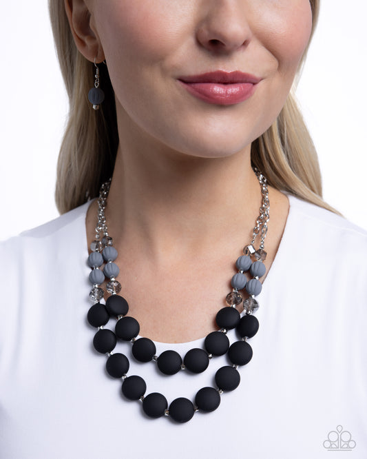 Whimsically Wealthy Black Necklace - Paparazzi Accessories Smoky faceted beads, silver beads, Sharkskin beads, and black matte beads are infused along classic silver chains that layer below the neckline for a colorfully charismatic look. Features an adjustable clasp closure. Sold as one individual necklace. Includes one pair of matching earrings. SKU: P2WH-BKXX-325XX