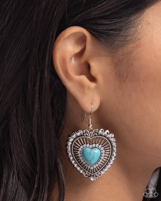 Antiqued Advocate Turquoise Heart Earring - Paparazzi Accessories  Bordered by a collection of dainty opalescent gems, a turquoise stone-centered heart dangles from the ear. Airy silver filigree bursts around the dainty stone heart center for additional texture and detail. Earring attaches to a standard fishhook fitting. As the stone elements in this piece are natural, some color variation is normal.  Sold as one pair of earrings.  P5SE-BLXX-337XX