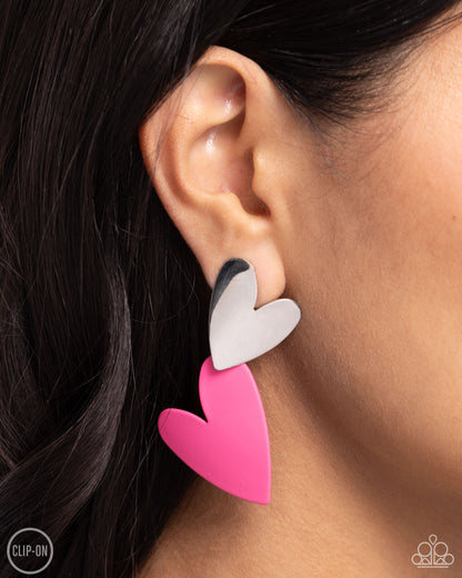 Romantic Occasion Pink Heart Clip-On Earring - Paparazzi Accessories  Dangling from a silver heart frame, another heart frame, this time an oversized one, features hot pink paint, creating an attention-grabbing romantic statement below the ear. Earring attaches to a standard clip-on fitting.  Sold as one pair of clip-on earrings.  P5CO-PKXX-049XX
