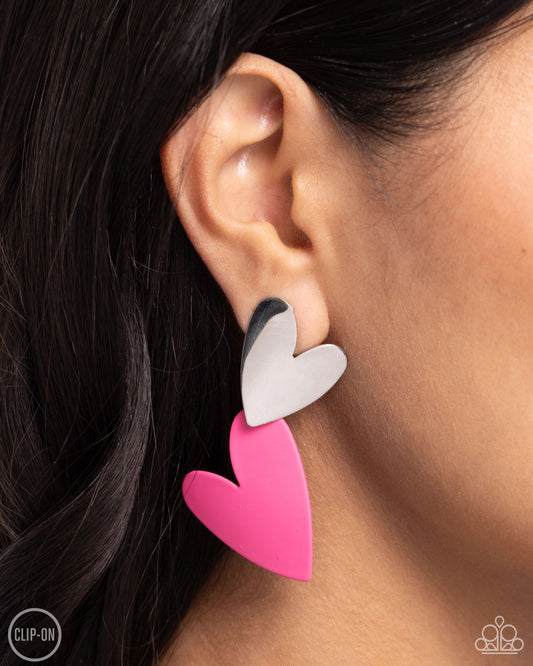 Romantic Occasion Pink Heart Clip-On Earring - Paparazzi Accessories  Dangling from a silver heart frame, another heart frame, this time an oversized one, features hot pink paint, creating an attention-grabbing romantic statement below the ear. Earring attaches to a standard clip-on fitting.  Sold as one pair of clip-on earrings.  P5CO-PKXX-049XX