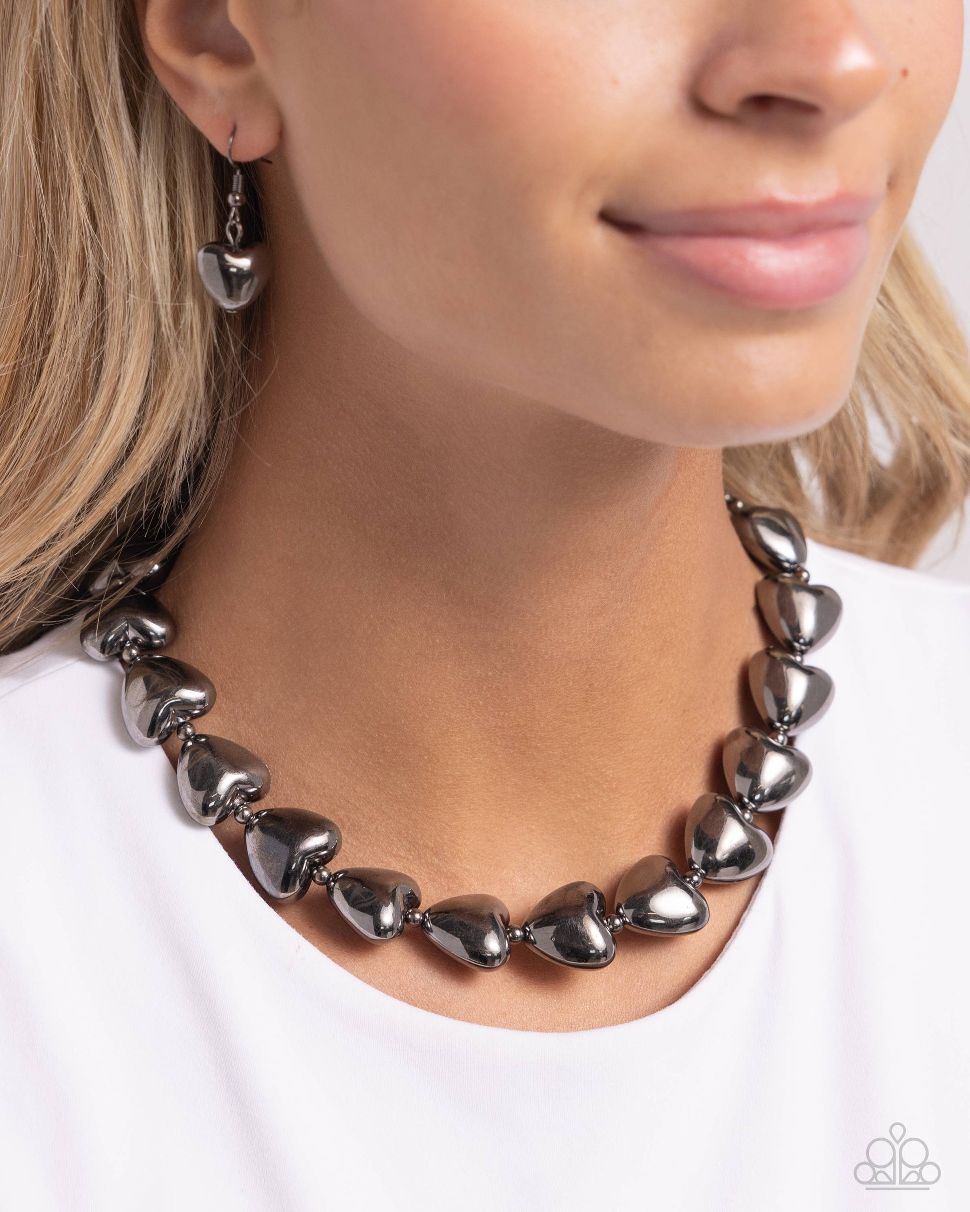 Hello Heartstrings Black Necklace - Paparazzi Accessories  Infused along a classic gunmetal chain, sleek gunmetal hearts alternate with dainty silver beads along the neckline for a romantically refined statement. Features an adjustable clasp closure.  Sold as one individual necklace. Includes one pair of matching earrings.  P2BA-BKXX-060XX