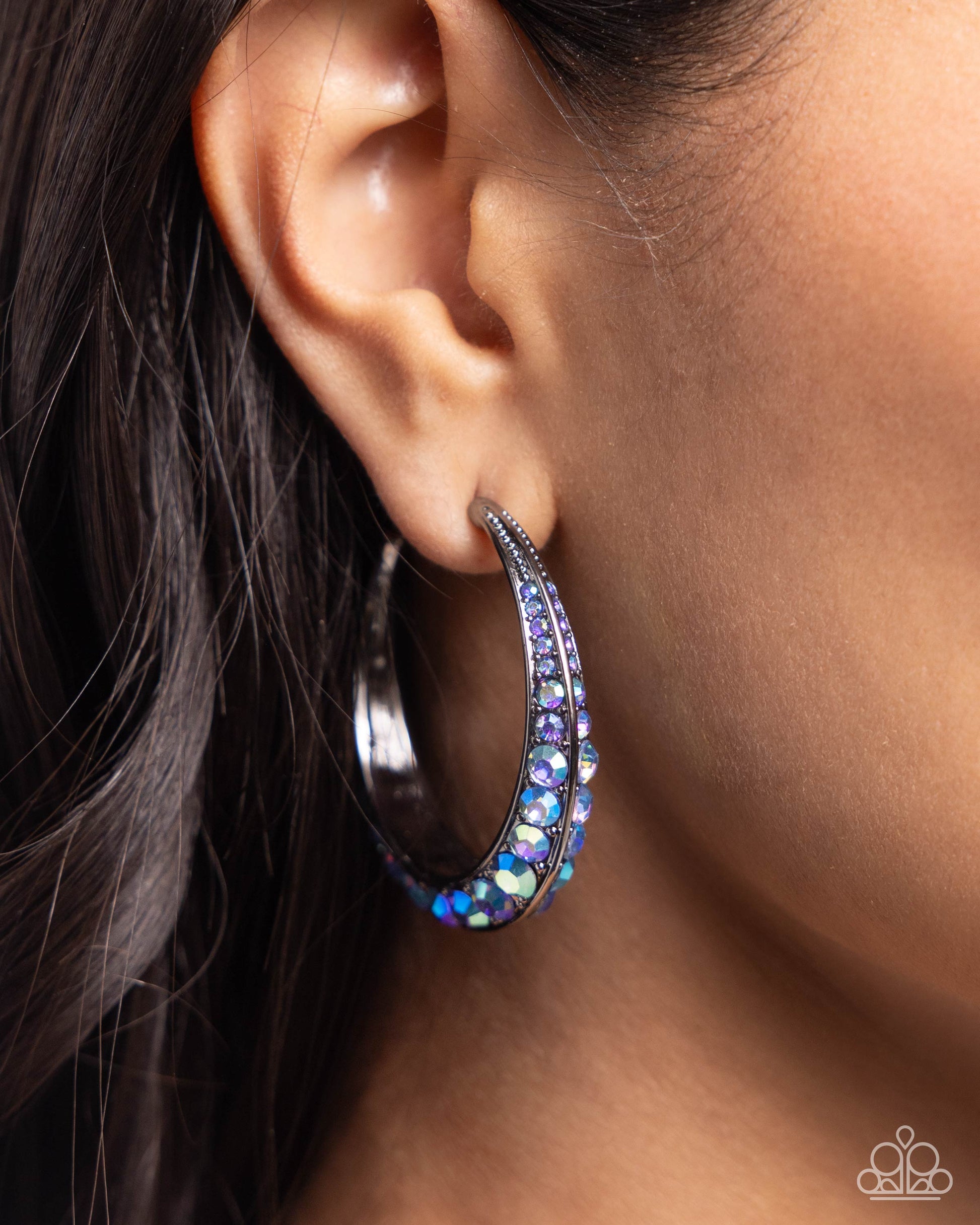 Embedded Edge Blue Hoop Earring - Paparazzi Accessories  The front-facing surface of a chunky gunmetal hoop is dipped in layers of brilliantly sparkling sapphire iridescent rhinestones that gradually increase in size towards the center of the hoop while light-catching gunmetal studs frame the ends for a blinding finish. Earring attaches to a standard post fitting. Hoop measures 1 3/4" in diameter. Due to its prismatic palette, color may vary.  Sold as one pair of hoop earrings.  P5HO-BLXX-055XX