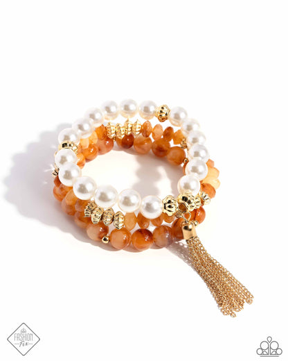 Marbled Mirage - Orange Item #P9RE-OGXX-070ZW   Threaded along stretchy bands, a collection of glossy white pearls joins textured and simple gold beads and orange-marbled faceted and simple beads, creating a refined stacked bracelet around the wrist. A single gold chain tassel dances from the dazzling compilation for some final finesse.  Sold as one set of three bracelets.