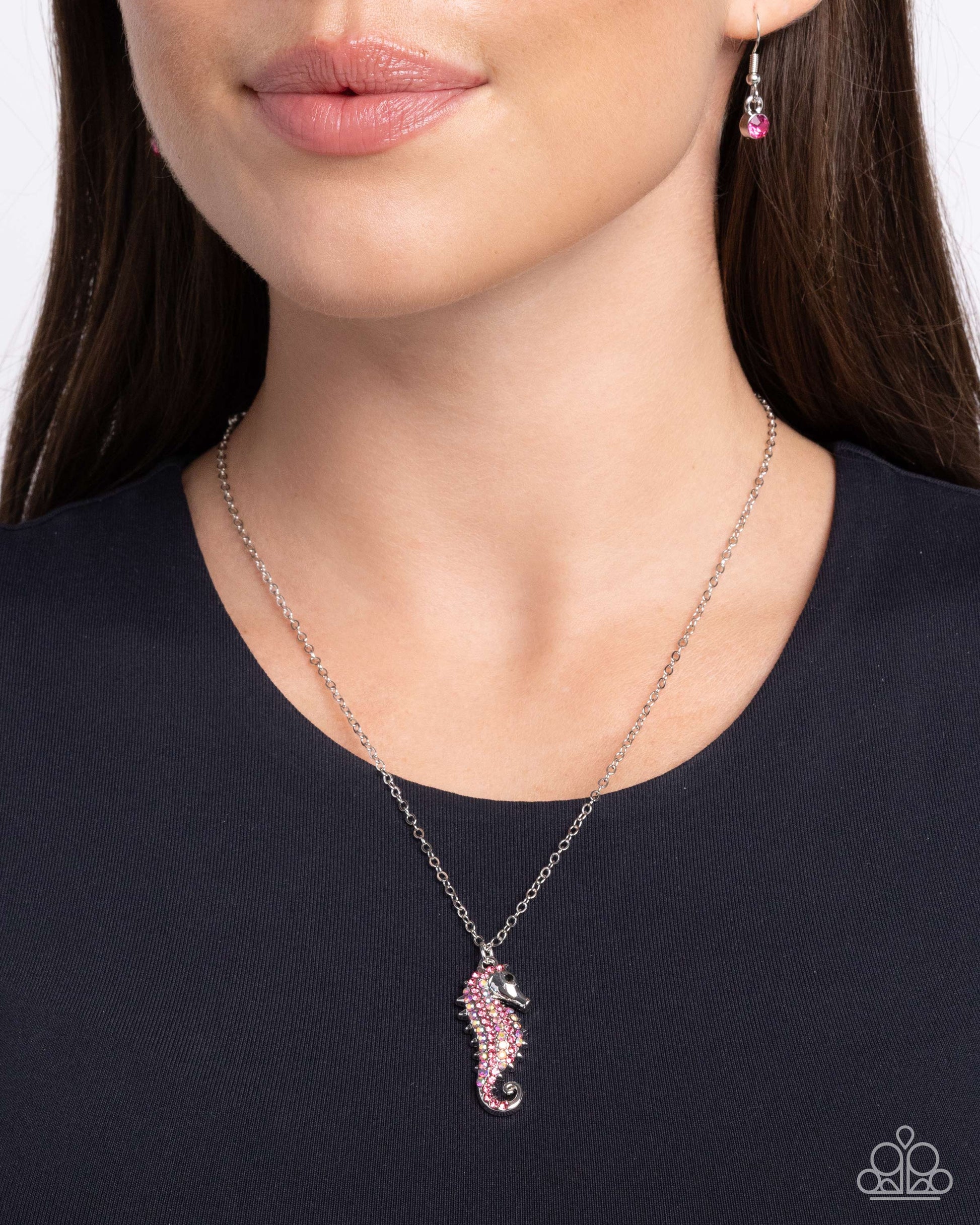 Seahorse Sailor Pink Necklace - Paparazzi Accessories  Gliding along a dainty silver chain, a rose, iridescent, and black rhinestone-embellished silver seahorse pendant shines below the neckline for a chic, coastal look. Features an adjustable clasp closure. Due to its prismatic palette, color may vary.  Sold as one individual necklace. Includes one pair of matching earrings.  P2DA-PKXX-209XX