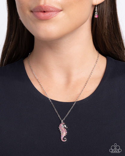 Seahorse Sailor Pink Necklace - Paparazzi Accessories  Gliding along a dainty silver chain, a rose, iridescent, and black rhinestone-embellished silver seahorse pendant shines below the neckline for a chic, coastal look. Features an adjustable clasp closure. Due to its prismatic palette, color may vary.  Sold as one individual necklace. Includes one pair of matching earrings.  P2DA-PKXX-209XX