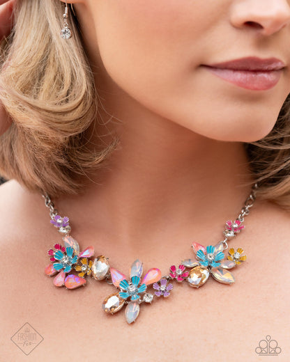Hamptons Haute - Multi Item #P2RE-MTXX-251AD    Featuring a spectrum of UV shimmer, faceted topaz, and pink gems, create abstract floral pendants along the neckline, accented by silver flowers with painted petals and additional white rhinestones from an abstract silver chain for a whimsical, coastal look. Features an adjustable clasp closure.  Sold as one individual necklace. Includes one pair of matching earrings.