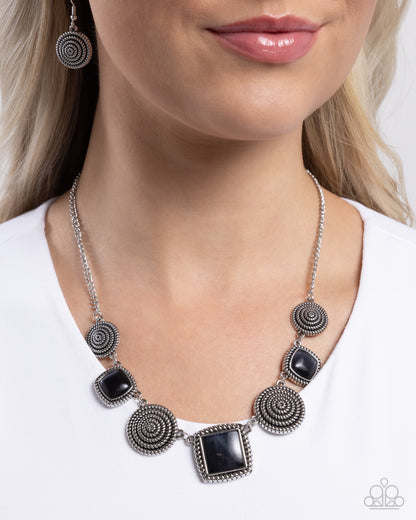Spiral Sass Black Necklace - Paparazzi Accessories  Pressed in textured spiral silver frames, a collection of glassy black cat's eye square stones alternate with glistening silver spirals along the neckline for a sassy showcase of color. Features an adjustable clasp closure.  Sold as one individual necklace. Includes one pair of matching earrings.  P2RE-BKXX-496XX