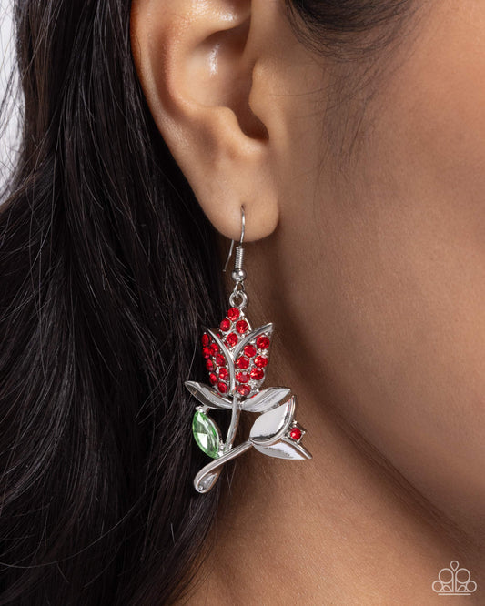 Tulip Tradition Red Flower Earring - Paparazzi Accessories  Featuring a duo of high-sheen silver tulips, one embellished in red rhinestones, the other featuring a solitaire red rhinestone, a solitaire marquise-cut green gem frames the twisted tulips for a leafy detail, creating a beautiful bloom along the ear. Earring attaches to a standard fishhook fitting.  Sold as one pair of earrings.  P5RE-RDXX-188XX