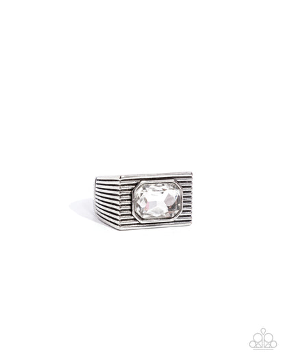 Knockout Tournament White Mens Ring - Paparazzi Accessories  A classic white emerald-cut gem sits atop a glistening silver square frame featuring linear texture, creating a bold urban centerpiece. Features a stretchy band for a flexible fit.  Sold as one individual ring.  P4MN-URWT-020XX