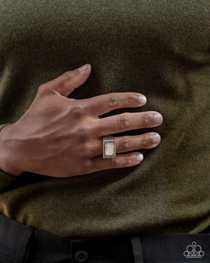 Knockout Tournament White Mens Ring - Paparazzi Accessories  A classic white emerald-cut gem sits atop a glistening silver square frame featuring linear texture, creating a bold urban centerpiece. Features a stretchy band for a flexible fit.  Sold as one individual ring.  P4MN-URWT-020XX