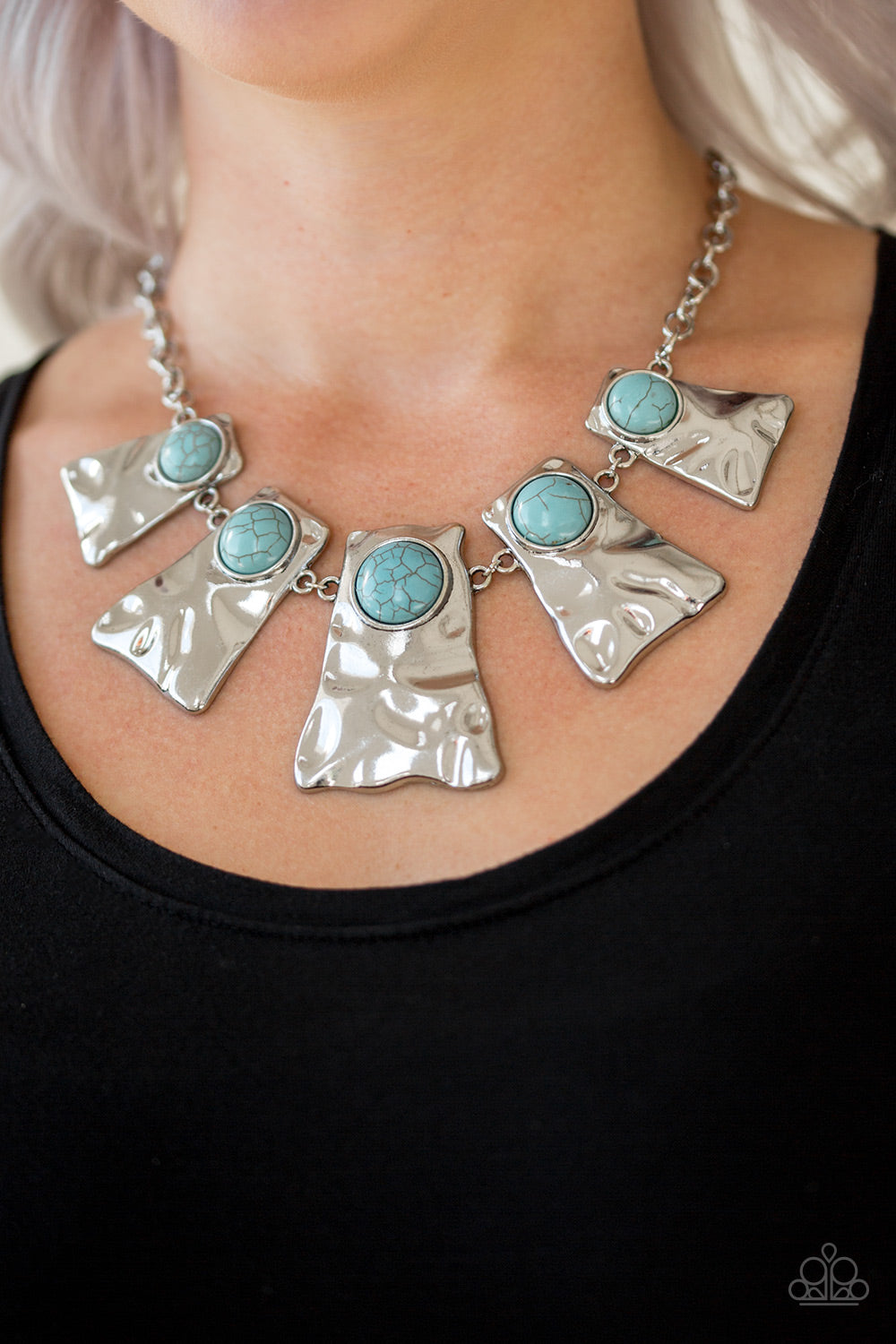 Cougar Blue Necklace - Paparazzi Accessories Item #JJG-N34 Rippling with hammered details, flared silver frames join below the collar, creating a fierce fringe. Refreshing turquoise stones are pressed into the tops of the frames for a colorful finish. Features an adjustable clasp closure. All Paparazzi Accessories are lead free and nickel free!  Sold as one individual necklace. Includes one pair of matching earrings.