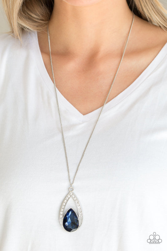 Notorious Noble - Blue Item #N191 A glittery blue teardrop gem is pressed into a silver frame radiating with glassy white rhinestones. The glamorous pendant swings from the bottom of a shimmery silver chain for a refined look. Features an adjustable clasp closure.  Featured inside The Preview at ONE Life!  Sold as one individual necklace. Includes one pair of matching earrings.